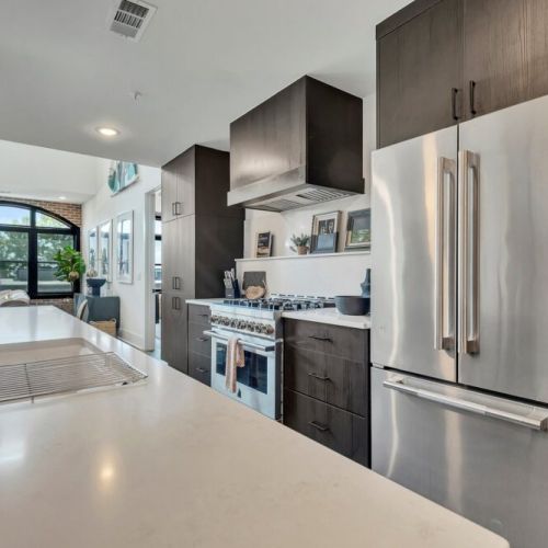 Kitchen island w/ dishwasher, open shelving & modern lighting overhead