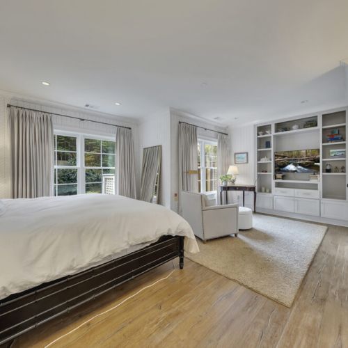 Bedroom 5 - Wall-to-wall built-in shelving with TV and storage.