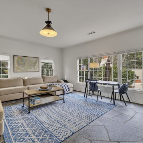Bright living area w/ hardwood floors & layered lighting throughout