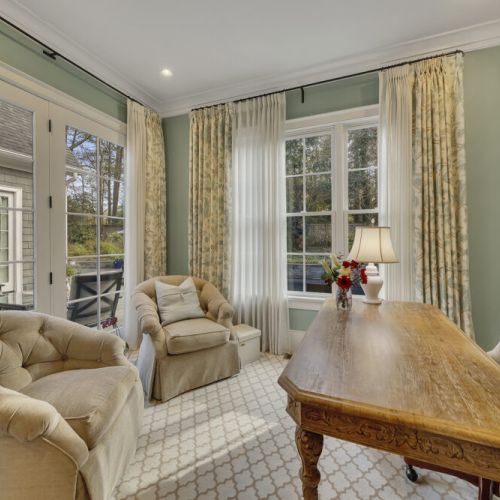Bedroom 1 en suite office. Elegant carved wooden desk  and plush tufted armchairs.