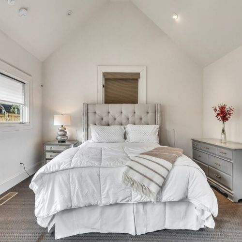 Cozy bedroom w/ tufted headboard & light-filled ambiance