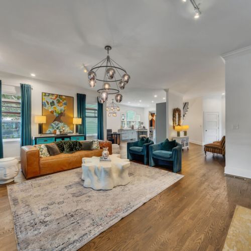 Two plush teal or deep turquoise velvet armchairs with ribbed backing are positioned in the foreground on the right.