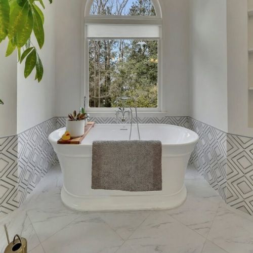Primary Bedroom - Freestanding soaking tub positioned under a large arched window