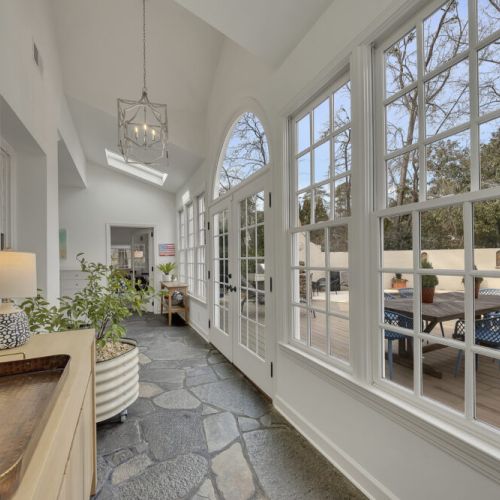 Sun-filled wall of windows overlooking the pool & outdoor deck