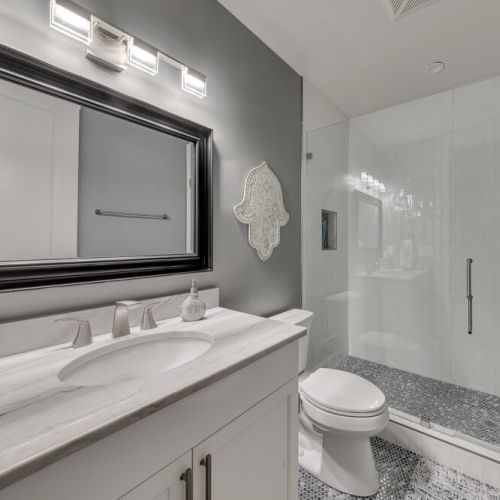 Bathroom w/ dual sink vanity & large mirror for easy routines