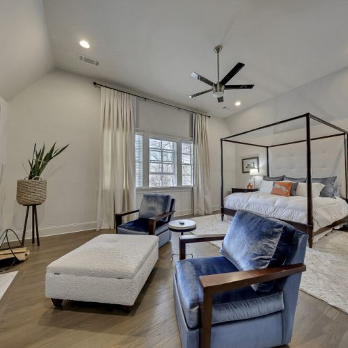 Bedroom w/ bed, seating area & ceiling fan for a comfortable retreat