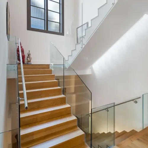 Modern staircase w/ wood steps & sleek metal handrails for a clean look