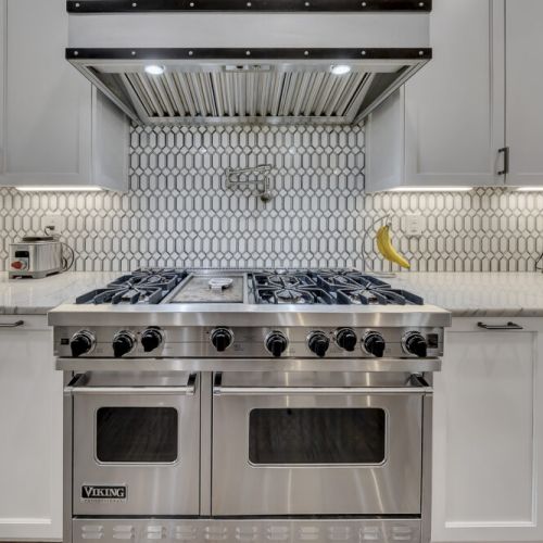 Chef-style range w/ tiled backsplash & double ovens, ready for home-cooked meals