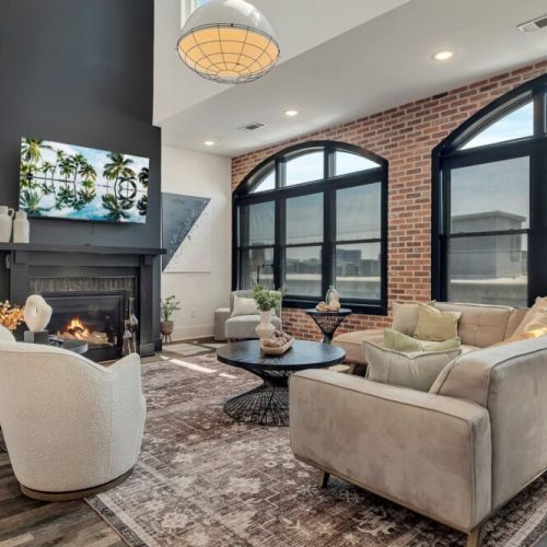 Bright, stylish living room with a cozy fireplace, comfortable seating, large windows, and beautiful natural light.