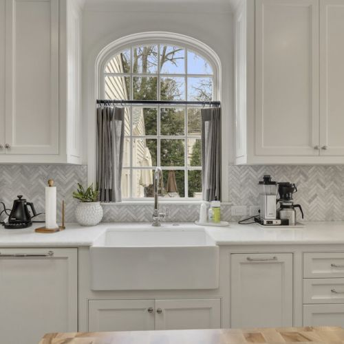 Farmhouse sink set beneath a window w/ peaceful yard views