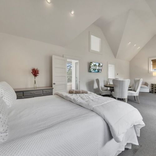Bright bedroom w/ soft tones & space for rest or work