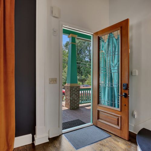 A vibrant entryway featuring a bold contrast between orange velvet curtains