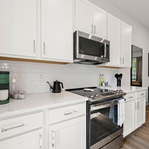 Fully equipped kitchen with a stainless-steel range, microwave, quartz countertops, and Keurig coffee maker. Ample cabinetry provides convenient storage for your cooking essentials.