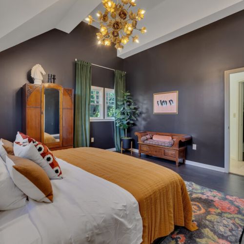 Behind the bed, a striking feature wall uses dark