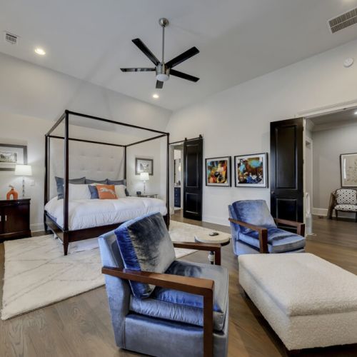 Bedroom w/ bed, seating area & ceiling fan for a comfortable retreat