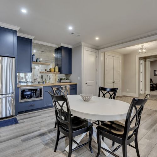 Lower kitchen w/ peninsula seating & open flow into dining area