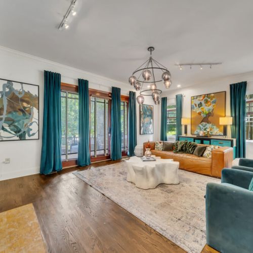 A large, tan or camel-colored leather sofa with tufted details is placed in the center-right of the room.