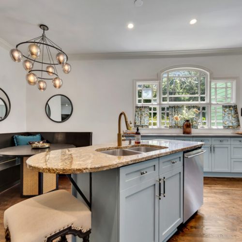 We're obsessed with this color! The gray-blue cabinets and cozy black banquette make for a stylish and functional kitchen.