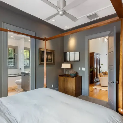Elegant bedroom w/ warm lighting & easy access to ensuite spaces