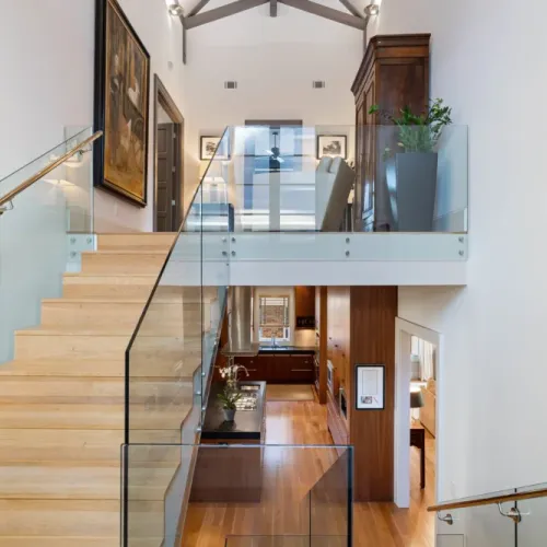 Sunlit stairwell w/ tall windows filling the space w/ natural light