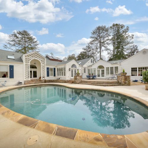 Elegant pool w/ smooth curves & stone detailing for a refined look