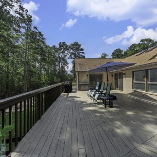 Massive wraparound deck overlooking the trees and lake