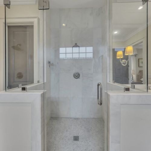 Bathroom 1 - Marble walk-in shower with frameless glass enclosure.