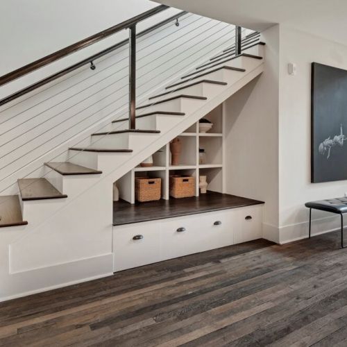 Modern staircase w/ cable railing, built-in storage & warm wood floors