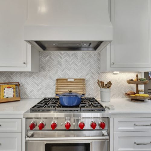 Professional gas range w/ custom hood & detailed backsplash