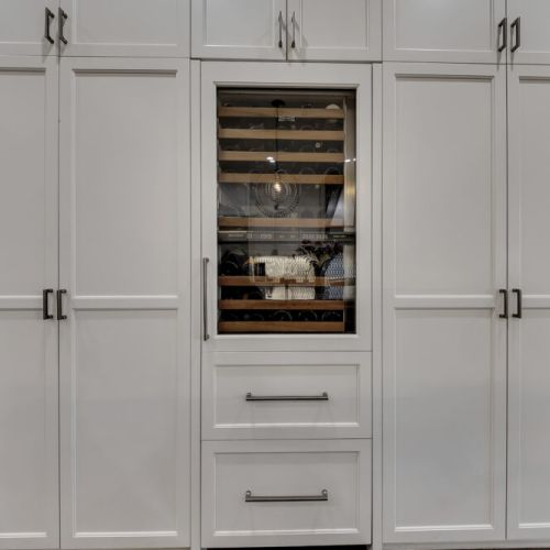Built-in wine fridge neatly tucked into cabinetry for easy access & entertaining