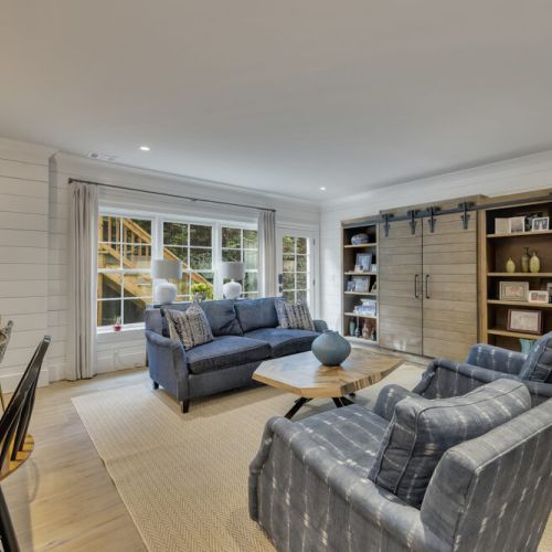 Basement Living room - Cozy sofa + accent chairs arranged around a unique wood coffee table.