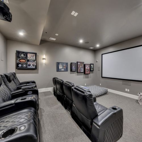 Home theater w/ reclining chairs & projector screen for immersive movie nights
