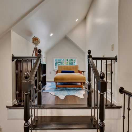 A view up a short flight of stairs with dark wood railings