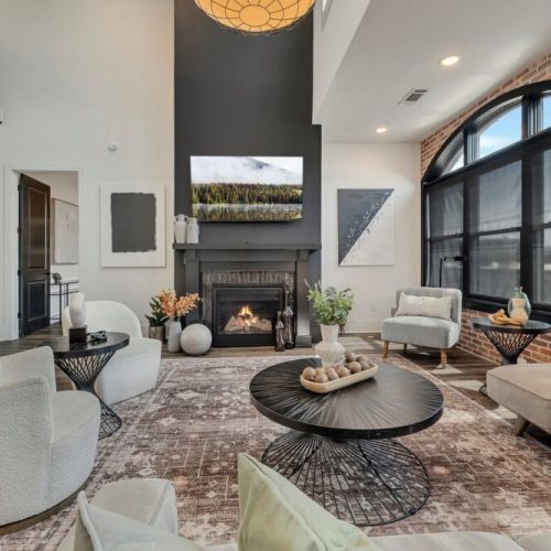 Spacious living room with a comfortable sectional, fireplace, large windows, and a relaxing contemporary design.