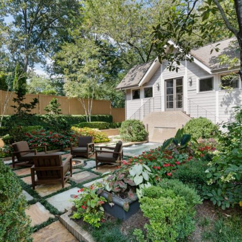 Lush garden beds w/ vibrant greenery & inviting outdoor seating