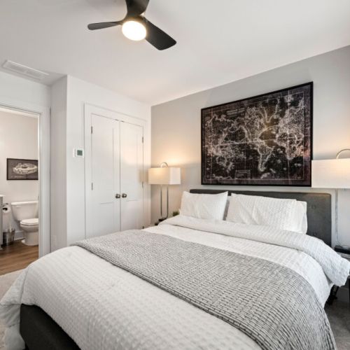Bedroom 1 - Cozy bedroom featuring a comfortable queen-size bed, ceiling fan, bedside lighting, and private bathroom access. Large windows bring in plenty of natural light.