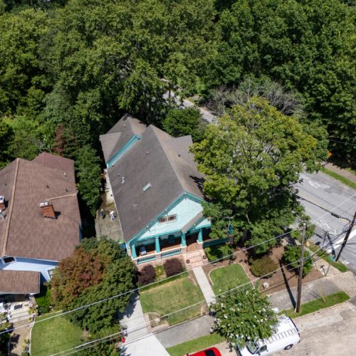 A charming Craftsman-style home featuring a bold mint green and teal exterior