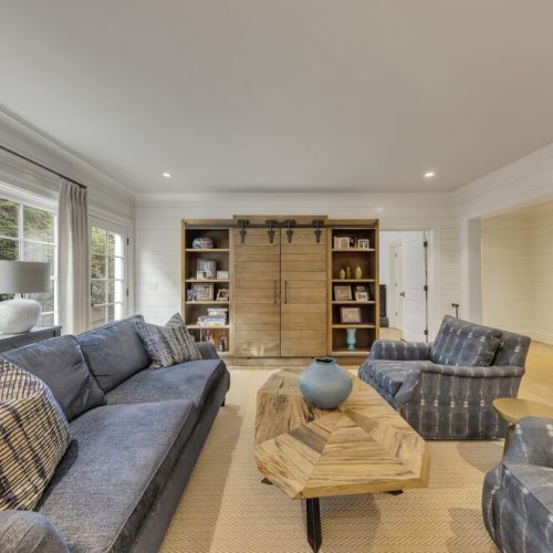Basement Living Room- Custom sliding barn-door shelving for books, décor & storage.