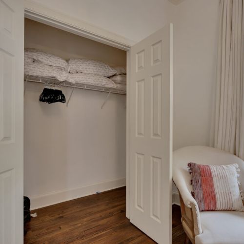 A view into an extra linen closet stacked with pillows