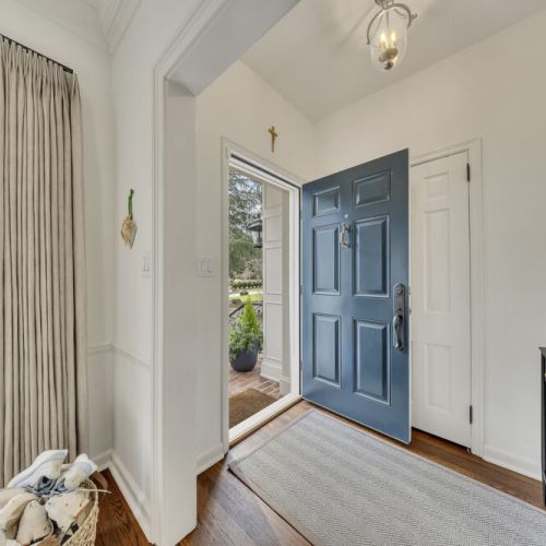 Welcoming entry w/ bold blue door & natural light greeting you inside