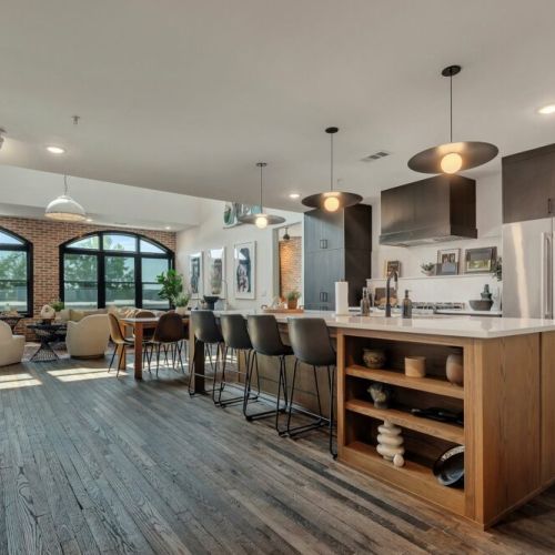 Sleek open kitchen w/ long island seating, pendant lighting & ample prep space