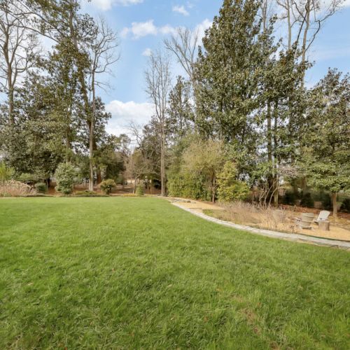 Wide open lawn framed by trees, perfect for outdoor activities