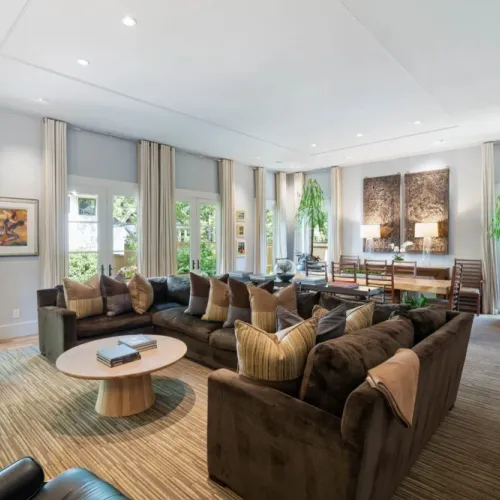 Inviting living room w/ oversized sectional & soft light pouring through large windows