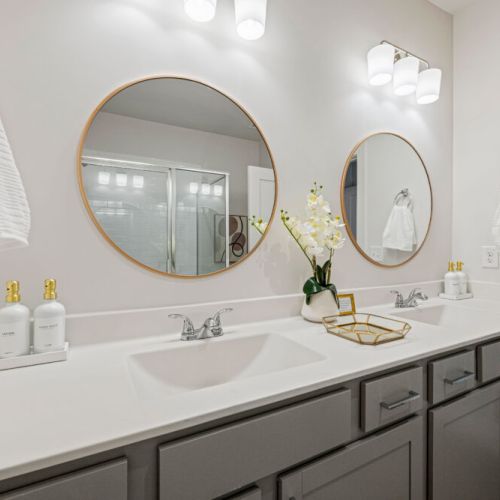 Full Bathroom 1 - Double-sink bathroom vanity with generous counter space, large mirrors, and complimentary hand soap and lotion—ideal for getting ready comfortably with your group.