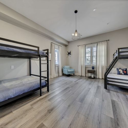 Bunk room w/ multiple beds & soft lighting, perfect for group stays