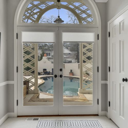 Elegant arched double doors with pool views