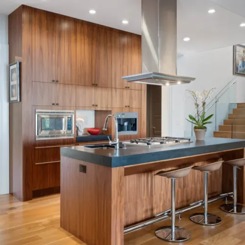 Sleek kitchen w/ stainless vent hood & warm wood cabinetry throughout