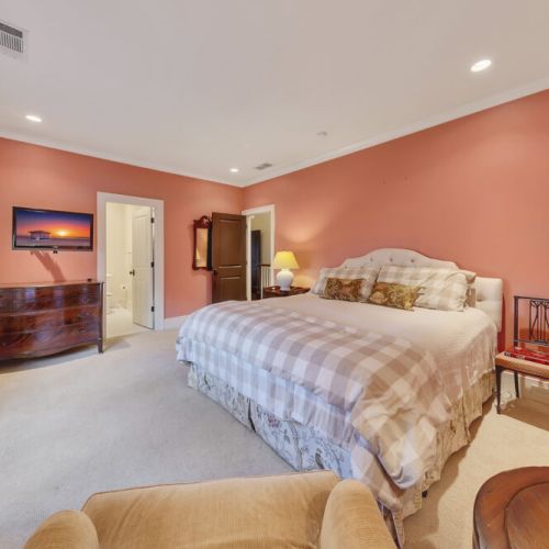 Bedroom 4 - King -sized upholstered bed with plush cushions and designer bedding.