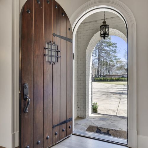 Grand front door entry w/ arched detail & natural light streaming inside