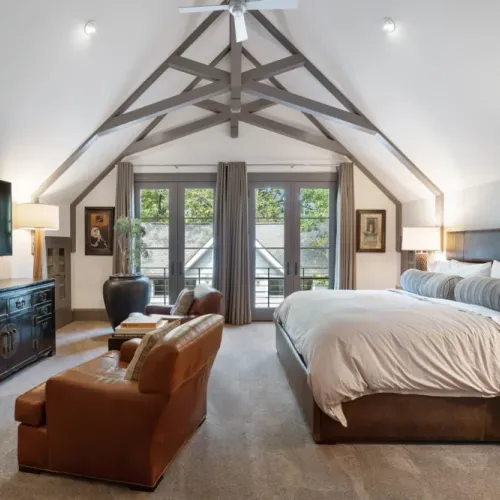 Airy bedroom w/ vaulted ceilings & French doors opening to a Juliet balcony